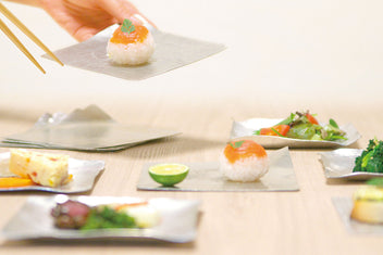 Flexible tin plates on a table with small food portions and chopsticks