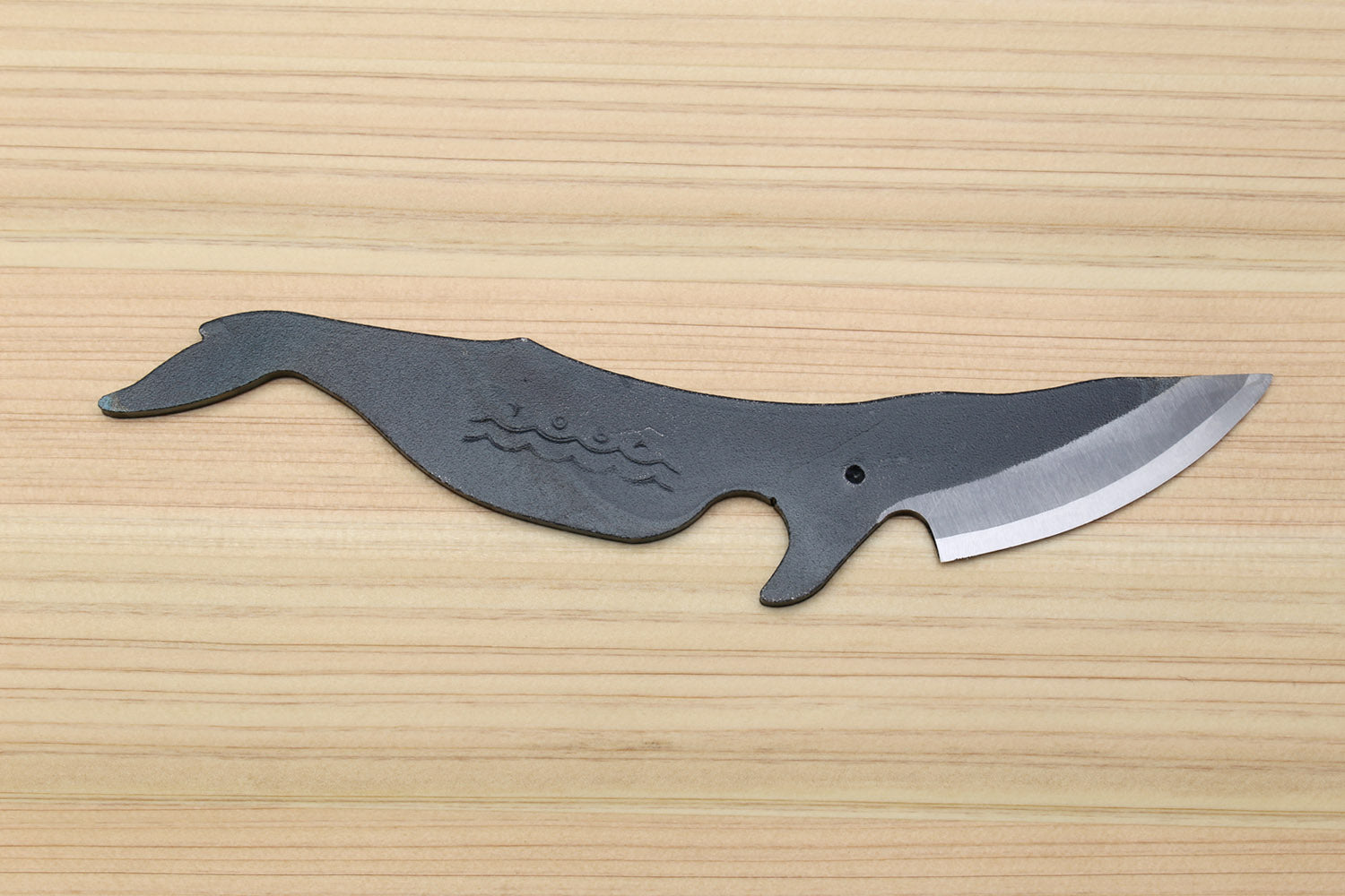 Utility knife with dark kurouchi finish, whale pattern, and pointed silver blade tip