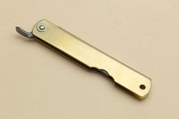 Kiridashi pocket knife with gold handle, metal clip, and extended pointed blade