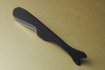 Utility knife back view with dark kurouchi handle and stamped logo on blade spine