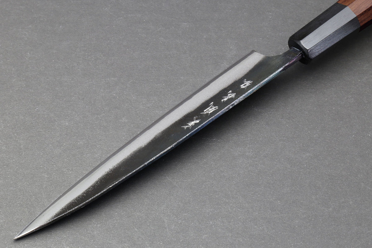 Petty utility knife with pointed tip, kurouchi blade, and dark wood handle