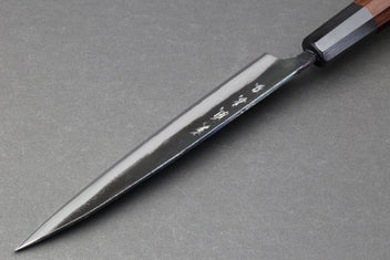 Petty utility knife with pointed tip, kurouchi blade, and dark wood handle
