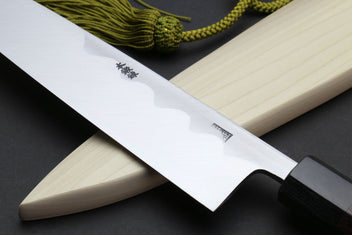 Japanese chef knife angled view with light saya and dark handle