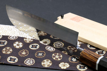Japanese chef knife showing flat grind blade and ebony handle with silver ring