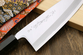 Deba knife blade close-up with engraved mark; ebony handle edge visible