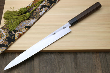 Sashimi knife with rosewood handle and slim silver blade on a wooden board
