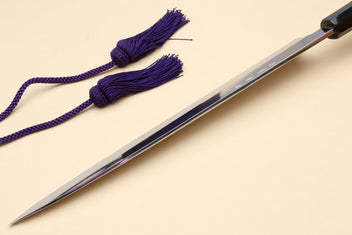 Yanagi sushi knife with mirror-finished blade, dark handle, and purple cord tassels
