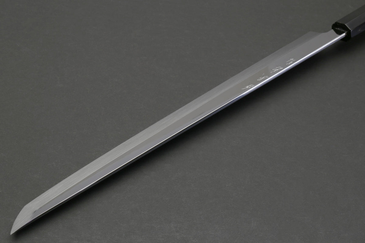 Japanese sushi knife side view with mirror-finished blade and dark ebony handle.