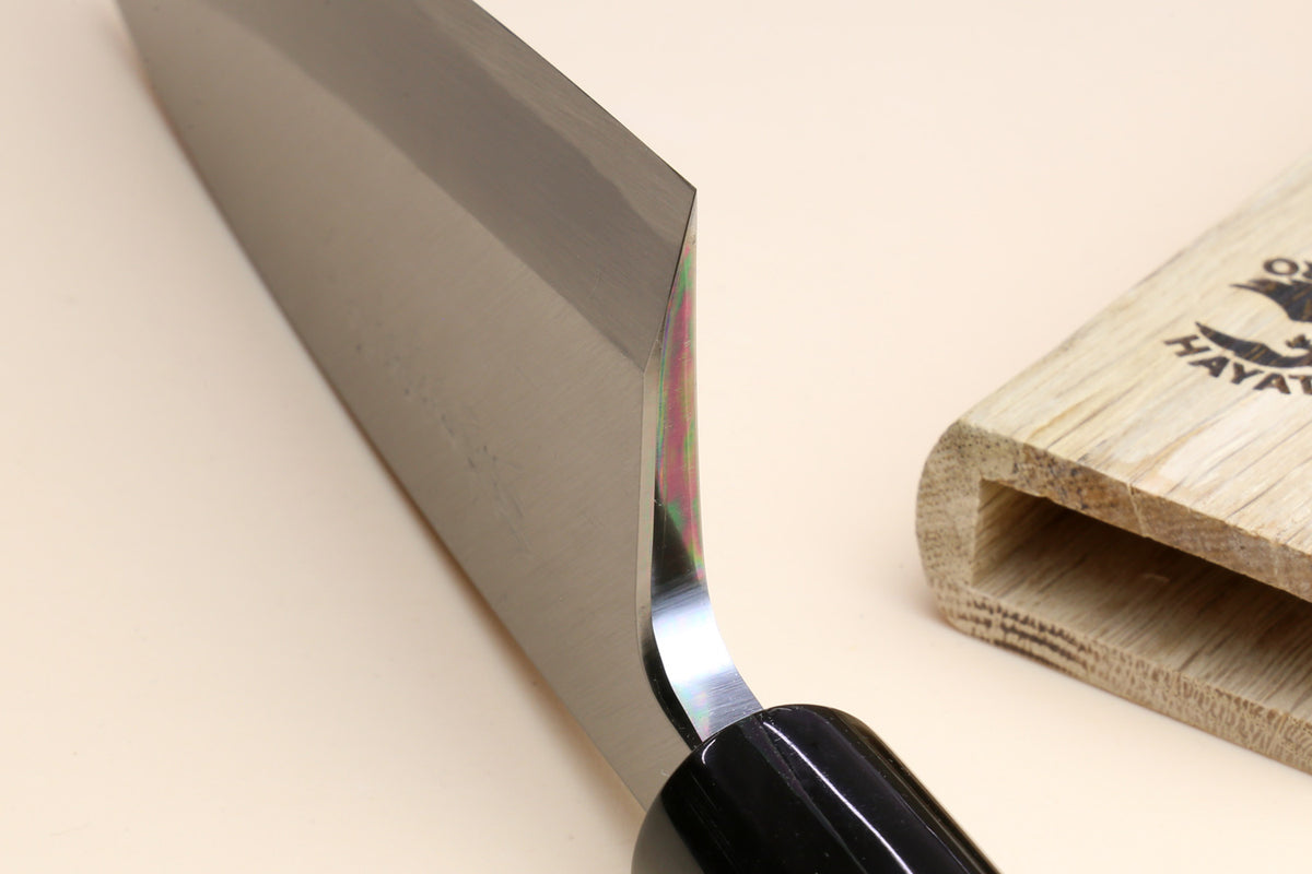 Deba knife close-up of dark rosewood handle and white steel blade at the spine
