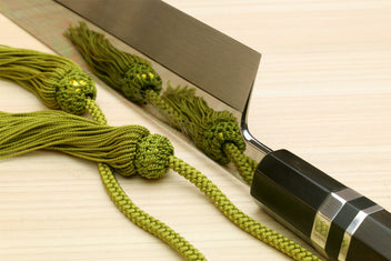 Mirror-polished Japanese vegetable knife with dark handle and silver ring, straight blade
