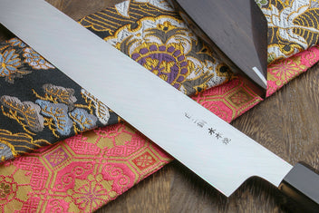 Japanese sushi knife blade close-up with mirror finish and engraved marks
