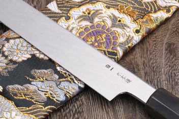 Yanagi knife blade close-up showing etched text and mirror-finished edge