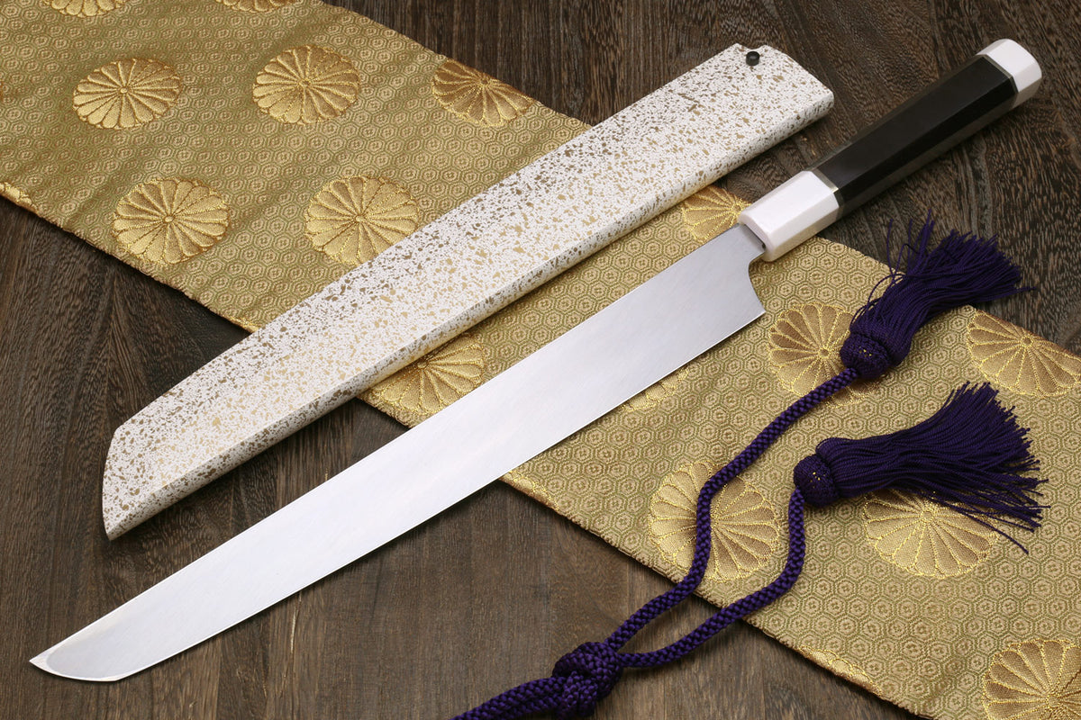 Japanese sushi sashimi knife with speckled white saya, exposed blade, and purple tassel cord