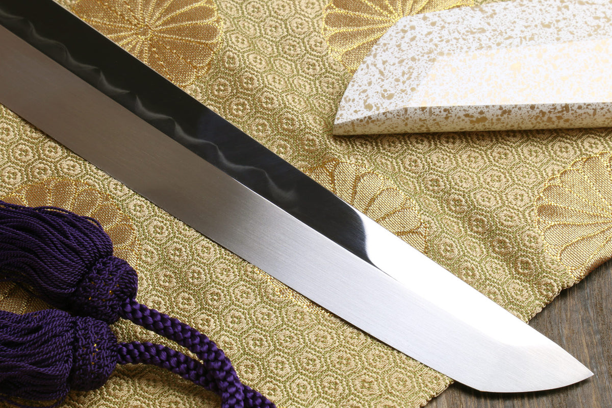 Japanese sushi sashimi knife with pointed blade tip, white handle cap, and purple cord