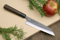Petty kiritsuke knife showing dark kurouchi blade edge and shitan handle