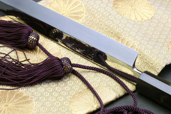 Close-up of Sakimaru sushi knife handle and mirror-polished blade edge
