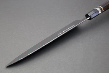 Gyuto chef knife angled view with mirror blade tip and dark ebony handle