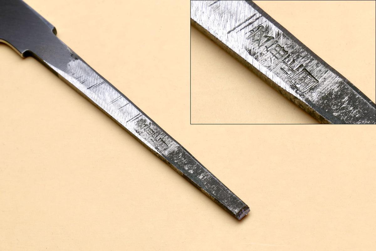 Japanese kitchen knife blade close-up with matte gray finish along the spine