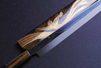 Yanagi kiritsuke knife close-up: gold-and-silver phoenix motif on mirror-finished blade