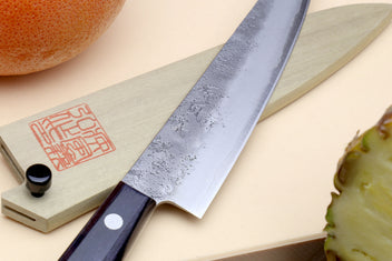 Petty utility knife with dark handle, silver blade, and engraved wooden saya cover