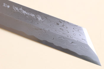 Japanese vegetable knife close-up of blue-steel blade with flowing damascus lines