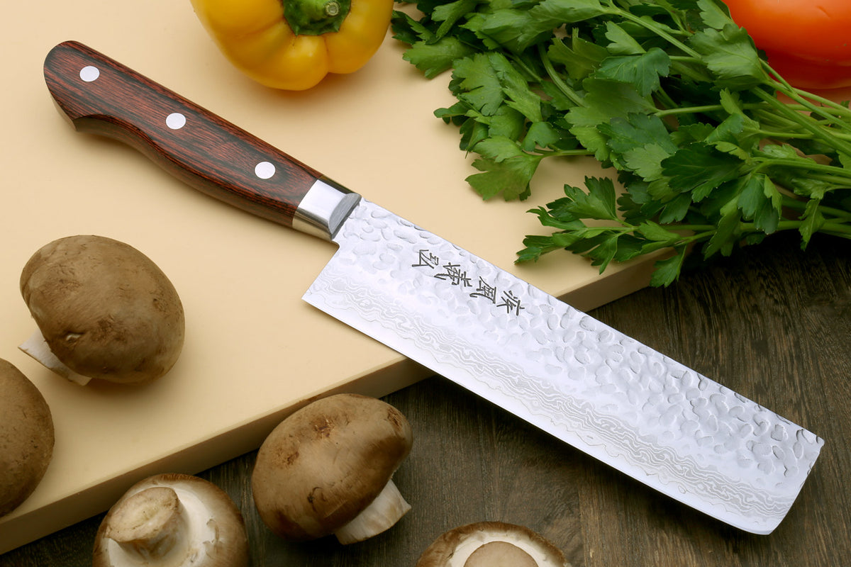 Nakiri chef knife, hammered Damascus steel blade with dark wood handle and rivets.