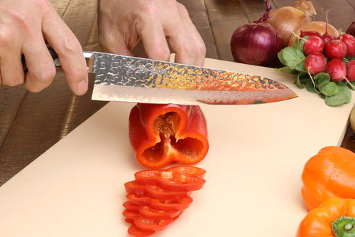 Knife cutting into bell pepper